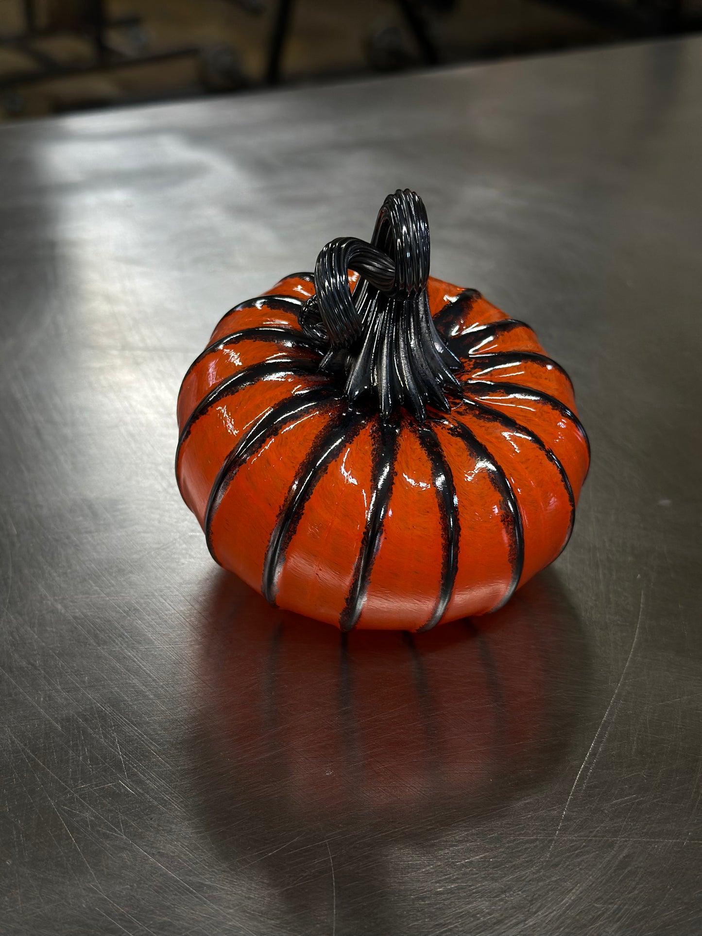 126 Bright orange and black glass pumpkin.